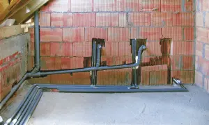 Instalacja hydrauliczna w trakcie budowy. Rury odpływowe i piony kanalizacyjne przygotowane do montażu, pokazujące jak zrobić odpowietrzenie WC.