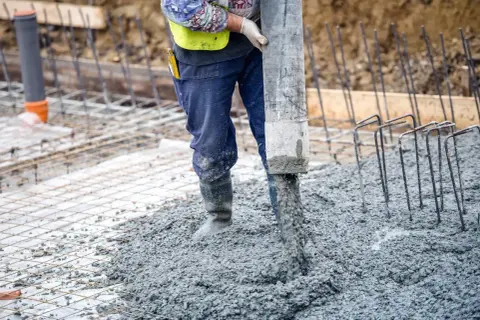 Robot wylewa beton na zbrojenie. Powstaje wylewka pod garaż.