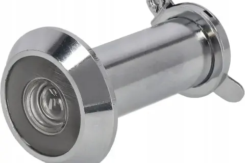 Metalowy judasz w drzwiach, gotowy do zamontowania, by bezpiecznie obserwować, kto stoi po drugiej stronie.
