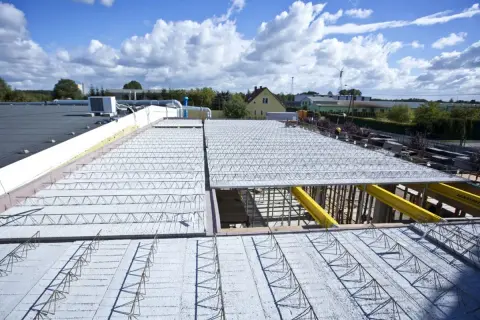 Budowa stropu: widok na elementy konstrukcyjne i zbrojenie. Widać siatkę stalową i beton.