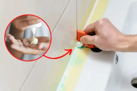 Jak usunąć silikon? Na dłoni widać białą pastę, którą aplikuje się na silikon przed jego usunięciem. Narzędzie usuwa silikon z wanny.